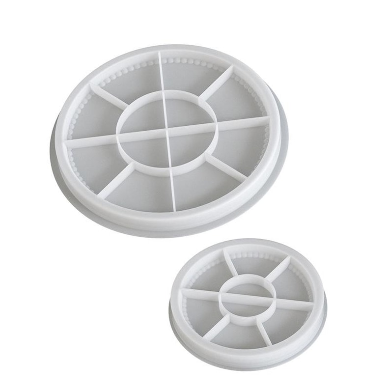 May include: Two white, circular silicone molds. The larger mold has a diameter of approximately 4 inches, and the smaller one is about 2 inches. Each mold is divided into sections by intersecting lines, creating a segmented design.