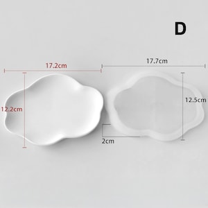 May include: Two cloud-shaped trays, one solid white and the other transparent. The white tray measures 17.2cm x 12.2cm. The transparent tray measures 17.7cm x 12.5cm. Both trays are 2cm thick. The letter "D" is in the upper right corner.