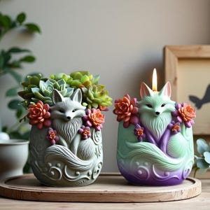 May include: Two fox-shaped decorative items. One is a planter with succulents and orange flowers. The other is a candle with a lit wick, featuring a fox design with orange and purple accents. Both are on a wooden tray.
