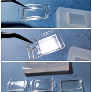 May include: Clear rectangular resin moulds with handles, shown in multiple views. One mould has a divider. The moulds are being held with tweezers. The background is a light blue surface.