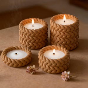 Może przedstawiać: Cztery zapalone świece w beżowych, plecionych świecznikach. Świece mają biały wosk i są otoczone tkaną fakturą. Małe suszone kwiaty umieszczono w pobliżu świec, tworząc ciepłą i zachęcającą atmosferę.