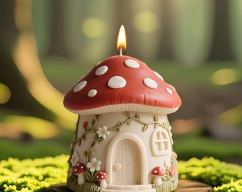 May include: A whimsical mushroom-shaped candle with a red cap dotted with white spots. The candle's base is a cream-colored house with a door, window, and floral accents. The candle sits on a wooden base, with a lit flame.