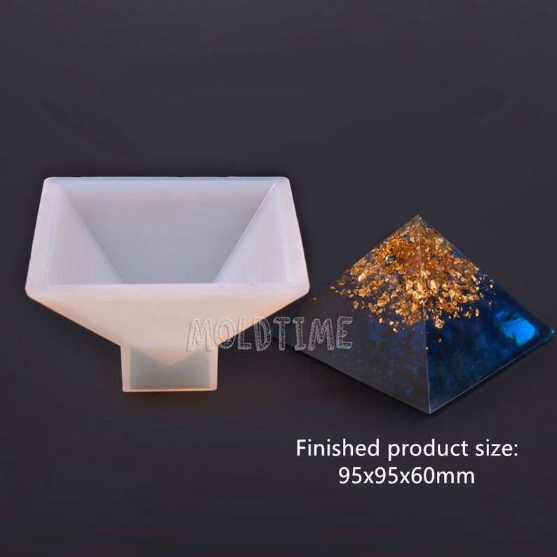 May include: A clear silicone pyramid mold next to a finished pyramid with gold leaf accents and a blue and black base. The text "MOLDTIME" is visible on the mold. The finished product size is 95x95x60mm.