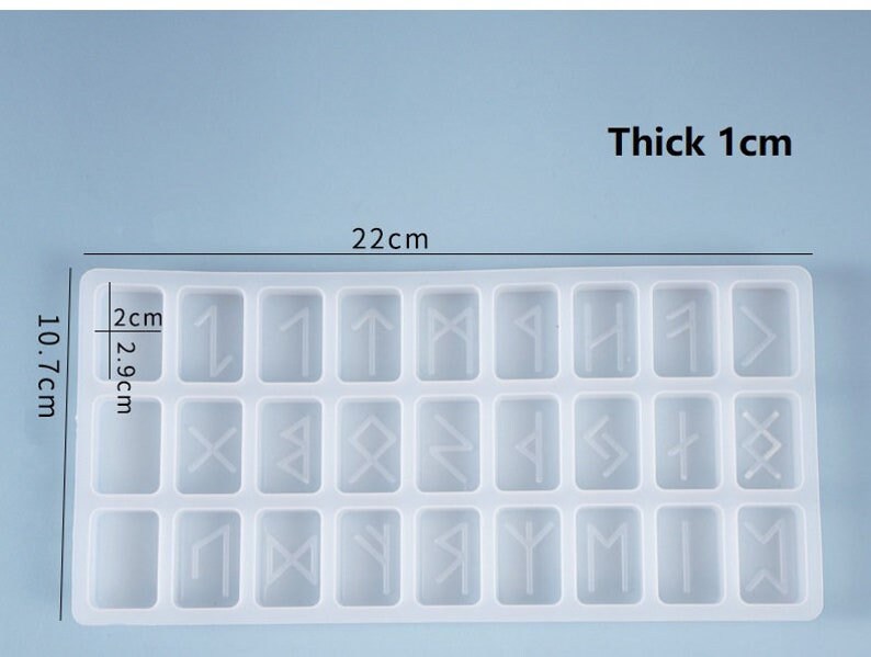 May include: A clear, rectangular silicone mold with 24 individual rune-shaped cavities. The mold is 22 cm long, 10.7 cm wide, and 1 cm thick. The dimensions of each cavity are 2.9 cm by 2 cm. The text "Thick 1cm" and measurements are visible.