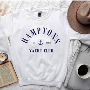May include: White sweatshirt with a navy blue graphic that says "HAMPTONS EST 1982 YACHT CLUB" with an anchor symbol.