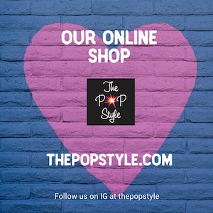 Peut inclure: Un c&oelig;ur rose peint sur un mur de briques bleues avec le texte "OUR ONLINE SHOP" au-dessus du c&oelig;ur. Le texte "THEPOPSTYLE.COM" est en dessous du c&oelig;ur. Un carr&eacute; noir avec le texte "The Pop Style" et une &eacute;toile rose est au centre du c&oelig;ur.