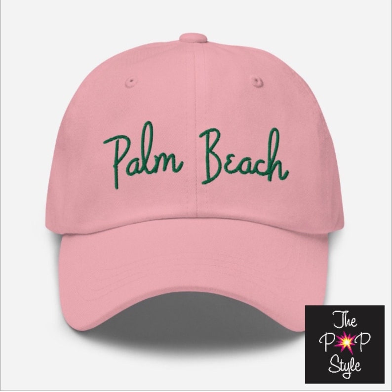 Może przedstawiać: R&oacute;żowa czapka z daszkiem z zielonym haftem z napisem "Palm Beach".