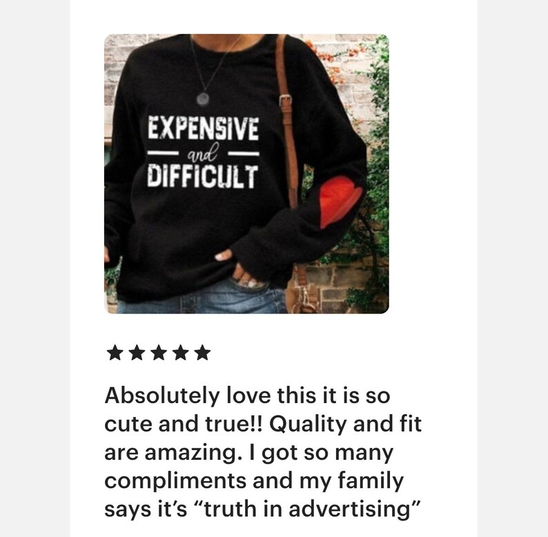 Peut inclure: Sweat-shirt noir &agrave; manches longues avec un patch en forme de c&oelig;ur rouge sur la manche gauche. Le texte "EXPENSIVE and DIFFICULT" est imprim&eacute; en blanc sur le devant.