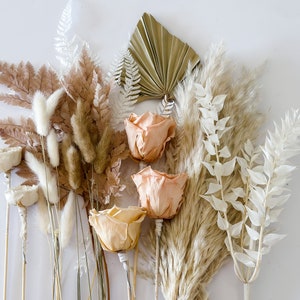 May include: A bouquet of dried flowers in shades of beige, cream, and peach. The bouquet includes roses, pampas grass, and other dried foliage.