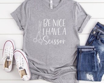 May include: Gray t-shirt with a white graphic that says "Be Nice I Have A Scissor" with a pair of scissors in the graphic.