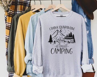 May include: Gray sweatshirt with a black graphic print of a mountain, a campfire, a tent, and a vintage camper van. The text reads "I think quarantine is spelled camping".