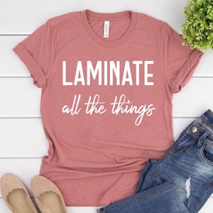 Puede incluir: Una camiseta de color rosa polvoriento con el texto "Laminate all the things" en blanco.