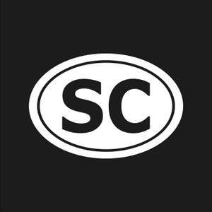May include: A white oval sticker with a black border and the letters "SC" in bold, black font. The sticker is set against a solid black background.