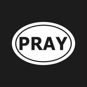 May include: A white oval sticker with the word "PRAY" in bold, black letters. The sticker has a black background and a white border, creating a simple, high-contrast design.
