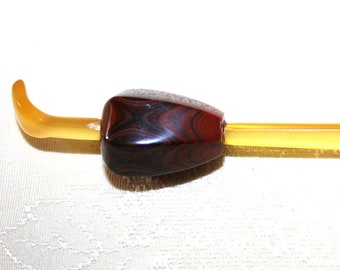 May include: A yellow and brown vintage knitting needle with a decorative wooden handle.