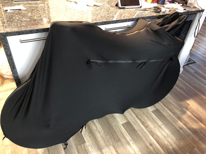 May include: A black bicycle cover with a zipper and a drawstring. The cover is made of a soft, stretchy material and is designed to protect your bike from the elements.