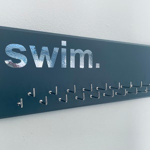 Swimming Medal Holder, grey or black with chrome or carbon silver &quot;swim.&quot; vinyl, Large 23 1/2 &quot; x 7 1/2&quot;, with 11 or 21 hooks.