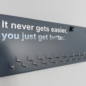 Triathlon / Running  Medal Holder, gray or black with chrome "It never gets easier, you just get better." vinyl, 21 hooks and BIB holder