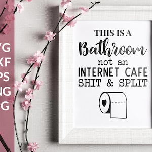 May include: A white framed sign with black text that reads "This is a Bathroom not an Internet Cafe Shit & Split". A black and white illustration of a toilet paper roll with a heart on it is below the text.