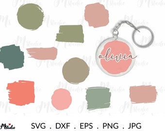 Pode incluir: Um conjunto de arquivos de corte digital para projetos de artesanato. O conjunto inclui uma variedade de formas e cores, incluindo círculos, quadrados e retângulos em tons de verde, rosa e marrom. O conjunto também inclui um chaveiro com a palavra "Olivia" escrita em rosa sobre um fundo rosa.