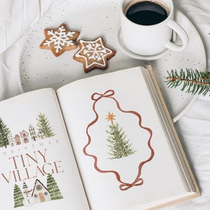May include: A festive scene featuring a book with Christmas illustrations, gingerbread cookies, and a cup of coffee. The book's cover reads "Christmas Tiny Village." A sprig of evergreen adds a seasonal touch.