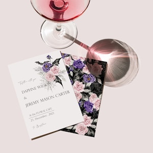 May include: A wedding invitation with a gothic floral design. The invitation features a black bat, spiderwebs, and purple and pink roses. The text reads "Together with you, Daphne Wilson & Jeremy Mason Carter, At the Floral Cafe, 23. December 2023, to Brighton."