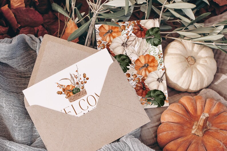 Peut inclure: Une enveloppe en papier kraft avec une carte blanche &agrave; l'int&eacute;rieur. La carte pr&eacute;sente une illustration aquarelle d'un panier rempli de citrouilles, de courges et de feuillage d'automne. Le texte "Bienvenue" est imprim&eacute; sur la carte. L'enveloppe est entour&eacute;e de feuilles d'automne, de citrouilles et de branches d'olivier.