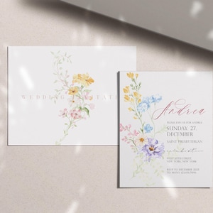 May include: Two white wedding invitation cards with floral watercolor designs. One card has the word "WEDDING" and "INVITATION" in a light brown font. The other card has the name "Andrea" in a cursive font and event details.