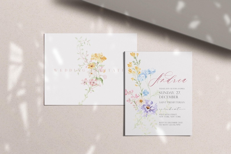 May include: Two white wedding invitation cards with floral watercolor designs. One card has the word "WEDDING" and "INVITATION" in a light brown font. The other card has the name "Andrea" in a cursive font and event details.