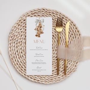 May include: A white rectangular menu card featuring a watercolor illustration of three gold bells tied with a grey ribbon at the top. The text reads MENU followed by First Course, Second Course, Main Course, and Dessert with listed items below.