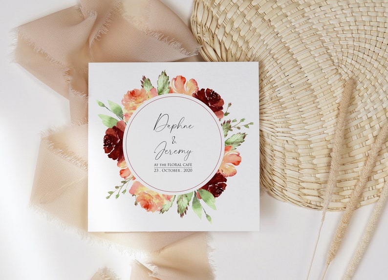 May include: A wedding invitation with a watercolor floral wreath in shades of red, orange, and green. The invitation reads "Daphne & Jeremy" and "At the Floral Cafe, 23 October, 2020".