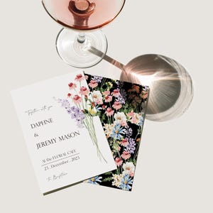 May include: Wedding invitation with a floral design. The invitation is white with black text that reads "Together with you, Daphne & Jeremy Mason, At the Floral Cafe, 23. December, 2023, To Bugetiene".