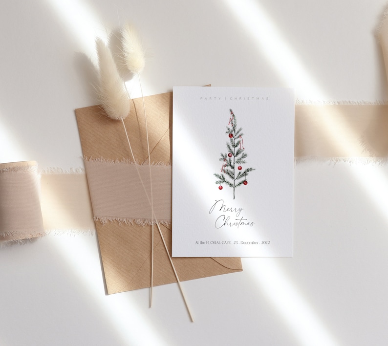 May include: A white card with a simple illustration of a Christmas tree with red ornaments and the text "Merry Christmas" and "At The Floral Cafe, 22 December 2022".