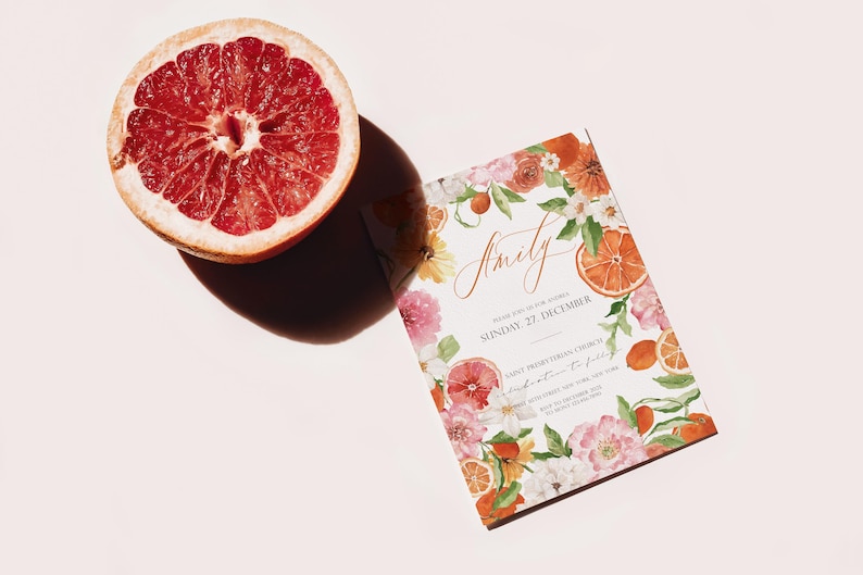 May include: A white wedding invitation with a floral design featuring oranges, lemons, and pink flowers. The text on the invitation reads "Emily" and "Sunday, 27 December".