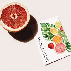 May include: A white card with the text "TROPICAL FRESH" in black lettering. The card features a watercolor illustration of a variety of tropical fruits, including a grapefruit, lemon, orange, kiwi, and strawberry, surrounded by green leaves.