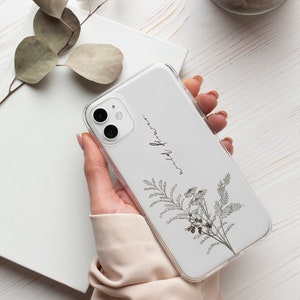 May include: A white phone case with a floral design and the text "wild flower" printed on it.