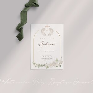 May include: A white baptism invitation with gold accents. The invitation features a watercolor illustration of white flowers and greenery, a gold cross with angel wings, and the text "Baptism Andrea Sunday, 27 December, at 12PM Saint Prothyrian Church celebration to follow".