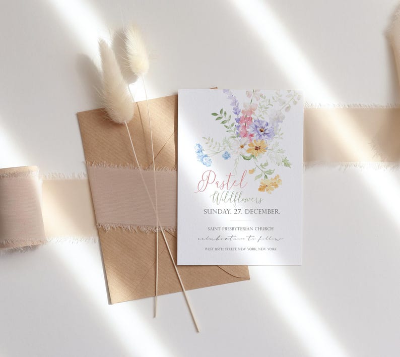 May include: A floral invitation card with the text "Pastel Wildflowers" and event details. The card features watercolor flowers in pastel colors. A brown envelope with a pink ribbon and dried flowers are also in the image.