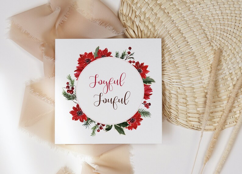 K&ouml;nnte beinhalten: Eine wei&szlig;e Karte mit einem roten Weihnachtsstern-Kranz und den Worten "Joyful Joyful" in einem Kreis.