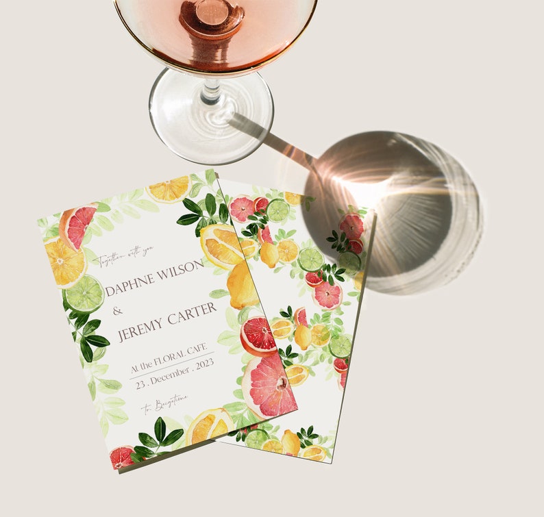 May include: A wedding invitation with a citrus fruit theme. The invitation is printed on white cardstock and features a watercolor illustration of lemons, limes, grapefruits, and leaves. The text on the invitation reads "Together with you, Daphne Wilson & Jeremy Carter, At the Floral Cafe, 23. December. 2023, to Beugatine."