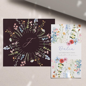May include: Two floral themed cards. The first card has a dark background with a circle of watercolor flowers in shades of blue, pink, and yellow. The center of the circle has a white letter "J". The second card has a white background with a cluster of watercolor flowers in shades of blue, pink, yellow, and red. The text "Dalia" is written in purple script at the top of the card. Below the text is "Saint Presbyterian Church" and "celebration to follow".
