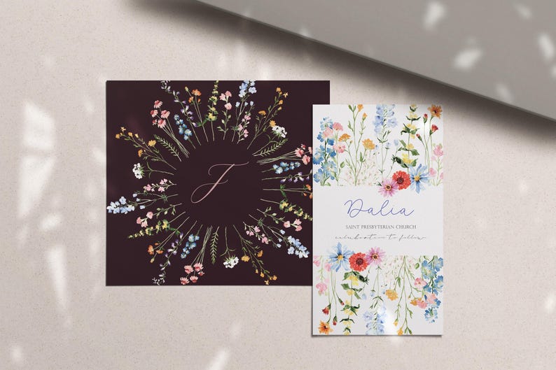 May include: Two floral themed cards. The first card has a dark background with a circle of watercolor flowers in shades of blue, pink, and yellow. The center of the circle has a white letter "J". The second card has a white background with a cluster of watercolor flowers in shades of blue, pink, yellow, and red. The text "Dalia" is written in purple script at the top of the card. Below the text is "Saint Presbyterian Church" and "celebration to follow".