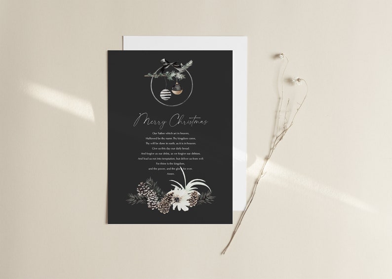 Puede incluir: Una tarjeta de Navidad en blanco y negro con un dise&ntilde;o simple que presenta un peque&ntilde;o &aacute;rbol de hoja perenne con adornos y un mensaje escrito a mano que dice "Feliz Navidad". El texto debajo del saludo es una oraci&oacute;n en texto blanco. La tarjeta est&aacute; decorada con pi&ntilde;as, ramas de hoja perenne y flores blancas.