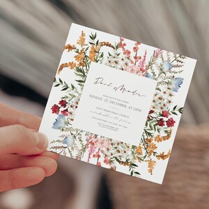 May include: A floral wedding invitation with a white background and a border of watercolor flowers in shades of pink, red, blue, and yellow. The text reads "Dear Mother, Please join us for Andrea & [unclear text] Sunday, 27 December at 12PM Saint Presbyterian Church Celebration to follow [unclear text] 27 December 20XX [unclear text] RSVP by 1 December 20XX [unclear text]