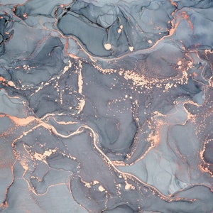 May include: Abstract art print featuring a fluid design in shades of gray and blue, accented with copper-colored metallic details. The artwork has a marbled effect, with flowing lines and speckled accents, creating a modern aesthetic.