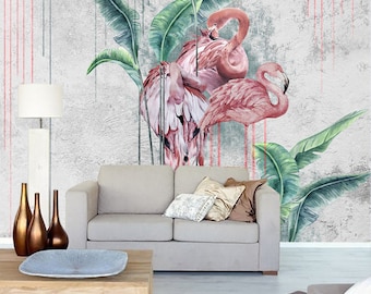 May include: A watercolor painting of two pink flamingos standing in front of a gray concrete wall with green banana leaves. The wall has red and pink paint streaks.
