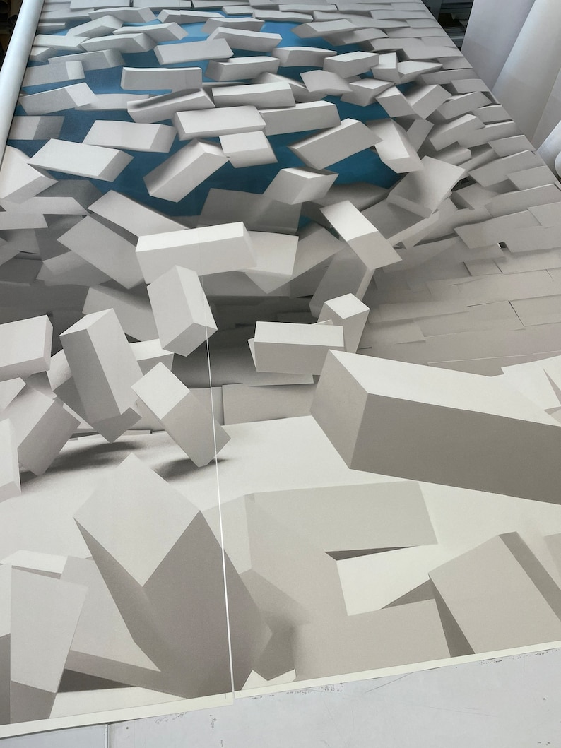 May include: Abstract 3D wall art featuring a white, textured, geometric design. The design appears to be made of stacked blocks that are falling apart, creating a sense of depth and movement.