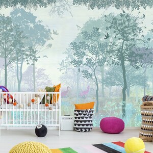 K&ouml;nnte beinhalten: Ein Kinderzimmer mit einem Wald-Themen-Wandbild in Blau- und Gr&uuml;nt&ouml;nen. Im Vordergrund befindet sich ein wei&szlig;es Kinderbett, das mit bunten Kissen und Pompons dekoriert ist. Weitere Dekorationen sind ein schwarz-wei&szlig; gemusterter Korb, ein rosa Pouf und ein schwarzes 8-Ball-Kissen.
