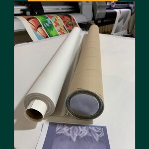 Puede incluir: Una impresi&oacute;n en lienzo blanco enrollada y lista para ser enviada en un tubo de cart&oacute;n marr&oacute;n. La impresi&oacute;n presenta un dise&ntilde;o de hojas tropicales.
