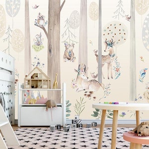 Puede incluir: Una litera de madera blanca con una escalera y un estante de almacenamiento de madera blanca con una casa de mu&ntilde;ecas en la parte superior. La pared detr&aacute;s de los muebles tiene un mural de bosque caprichoso con animales, &aacute;rboles y flores en estilo acuarela.